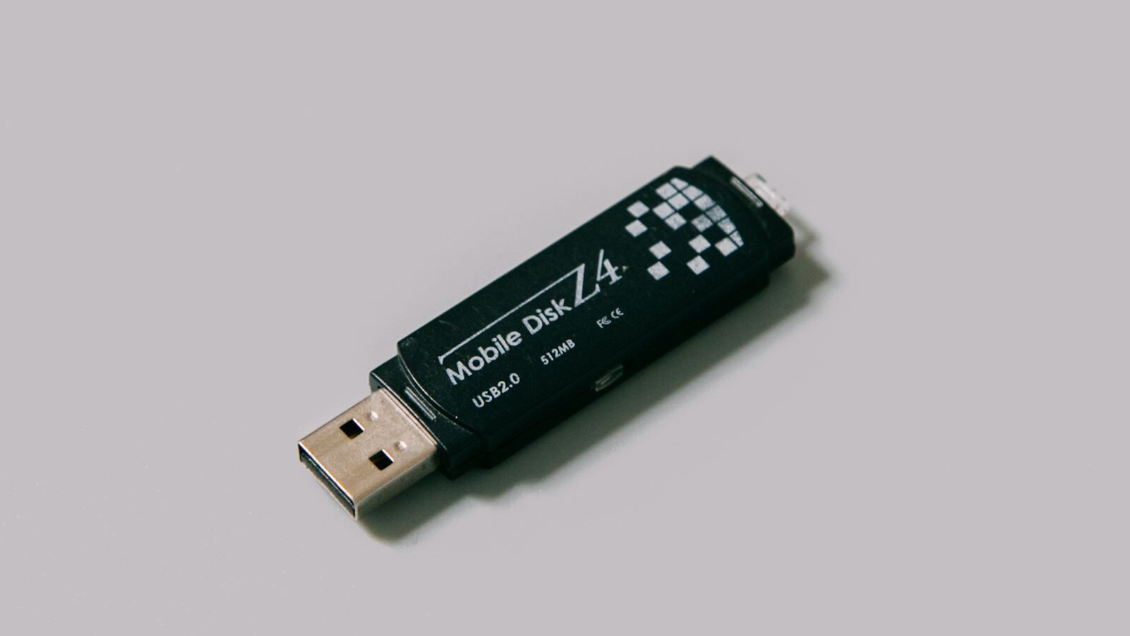 A USB flash drive beside a laptop