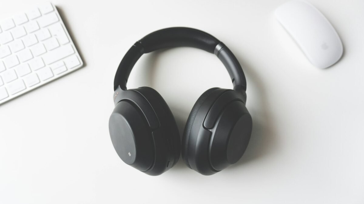 Over-ear headphones resting on a desk beside a laptop